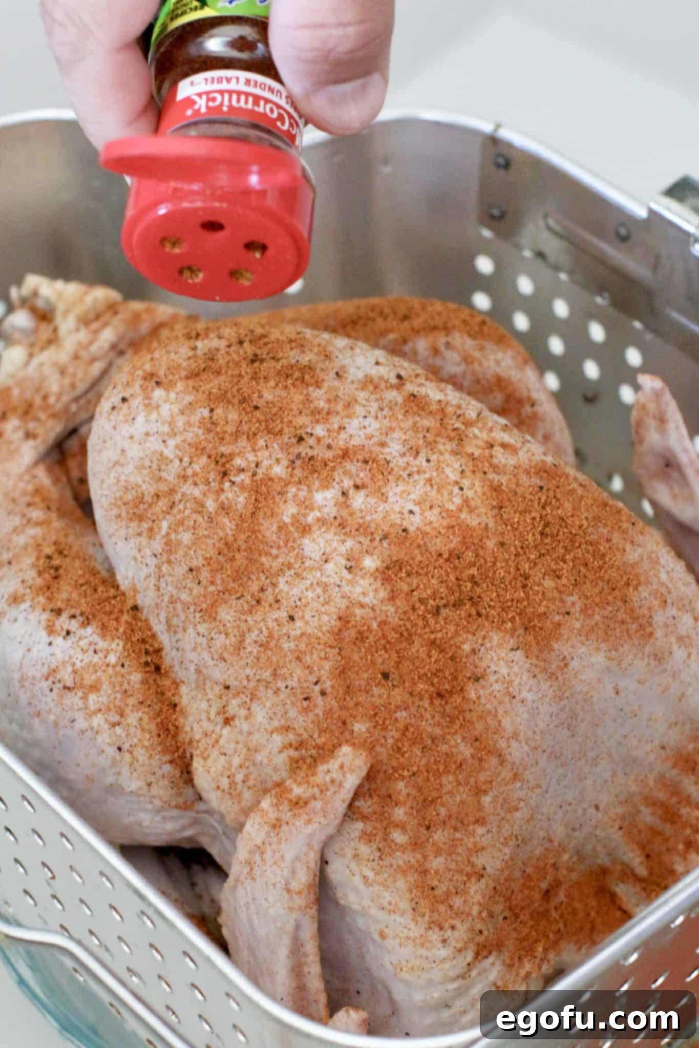 sprinkling rotisserie chicken seasoning onto a thawed turkey. 