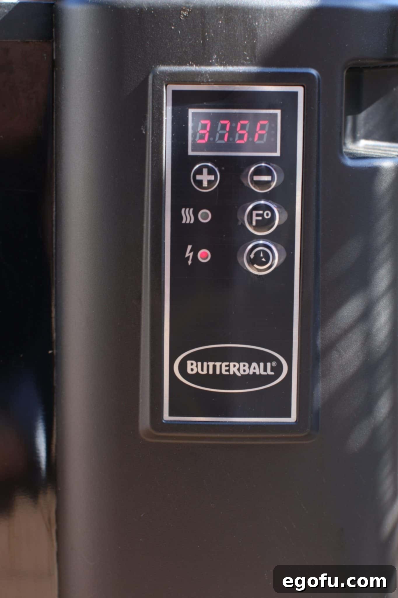 A digital temperature gauge on a turkey fryer showing 375F degrees. 