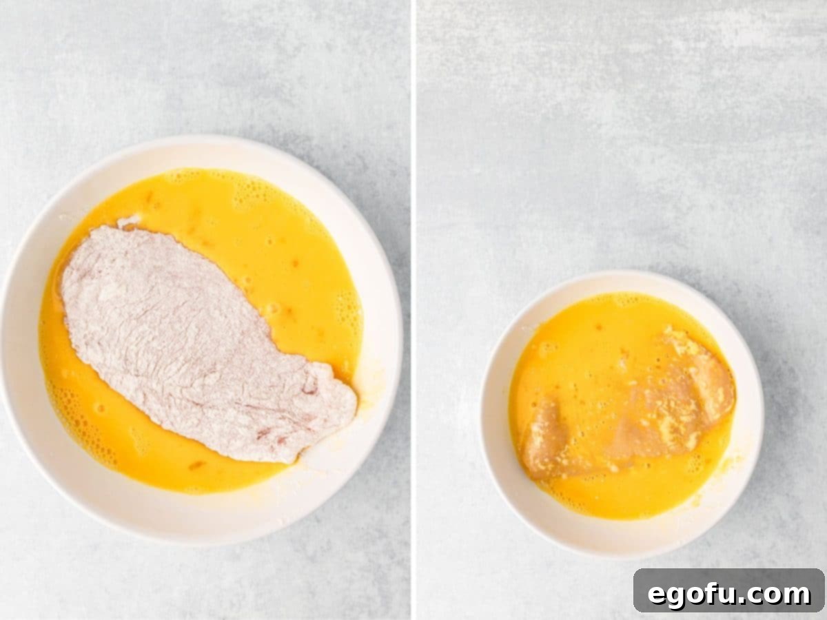 Flour coated chicken in an egg mixture. 