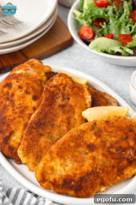 A few Chicken Schnitzels on a white serving platter.