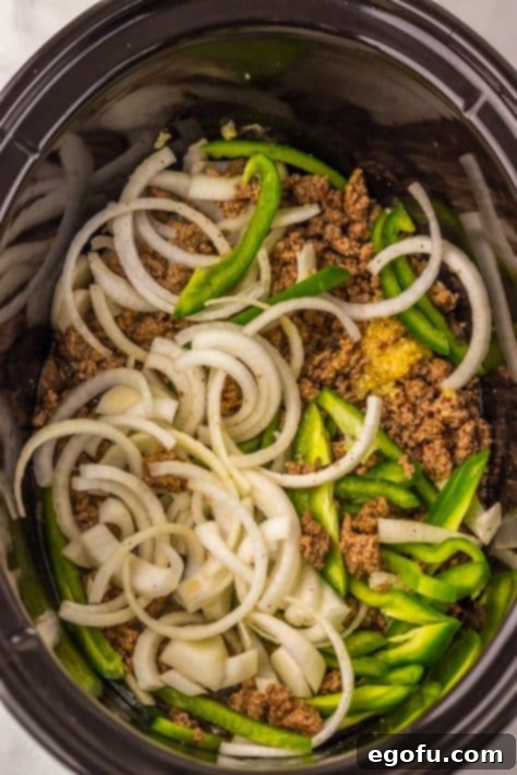 Cooked ground beef, onions, and peppers in a Slow Cooker.