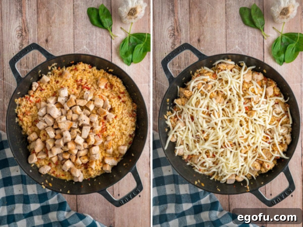 Cooked chicken and shredded mozzarella cheese being added to the rice in a skillet.