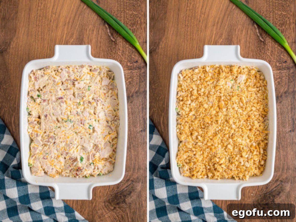 Chicken casserole mixture in a baking dish topped with Ritz cracker crumbs.