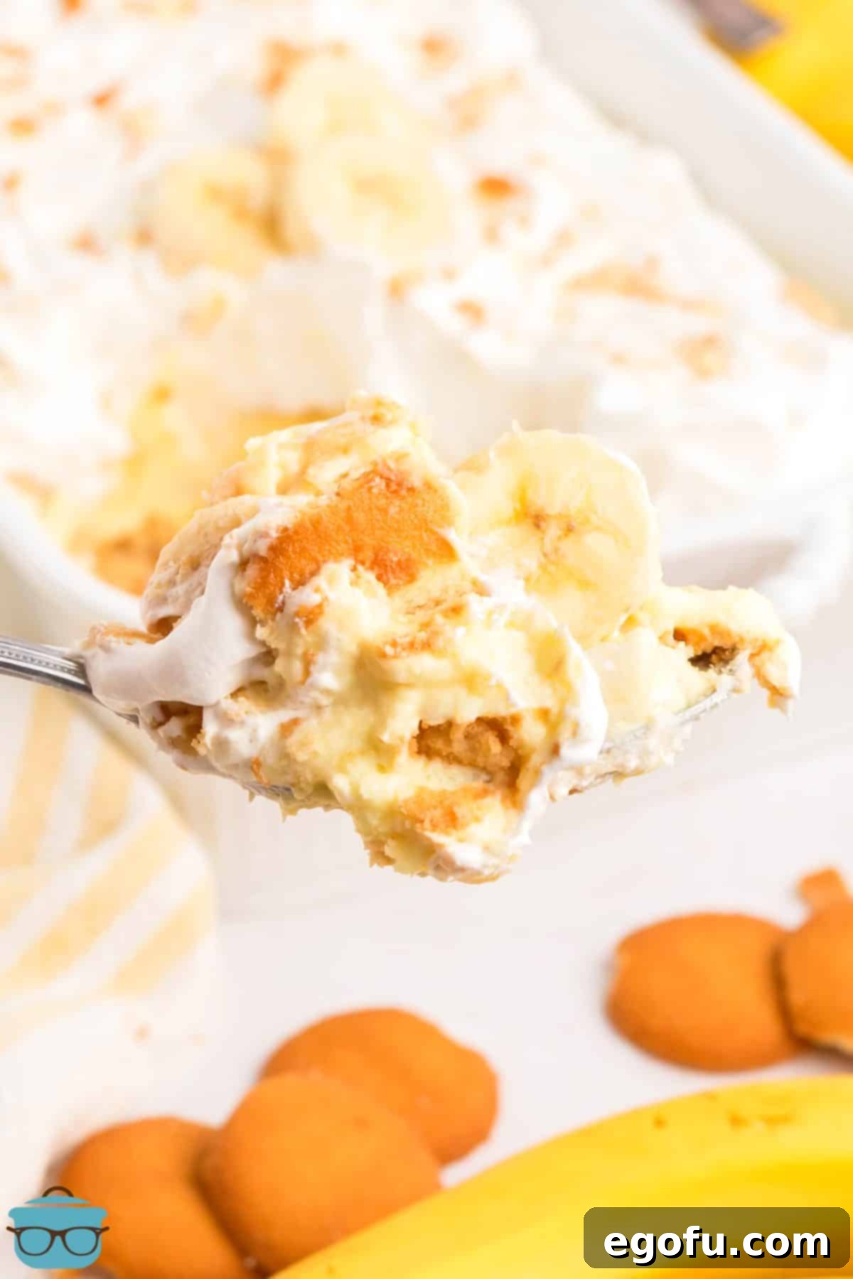A generous scoop of No-Bake Banana Pudding being served, showing its creamy layers and crushed wafer garnish.