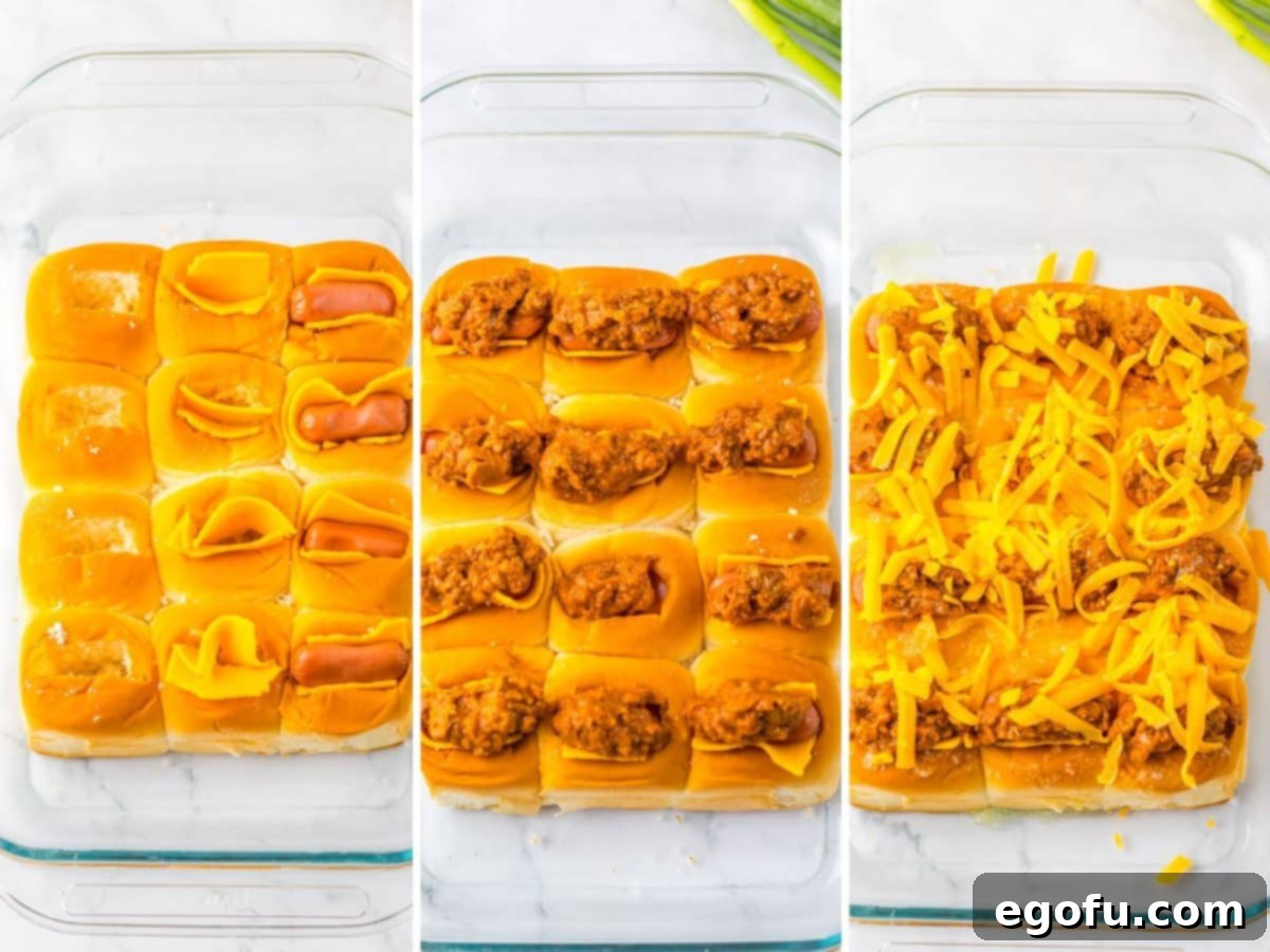 A baking dish with slider buns stuffed with chili, cheese, and sausages before baking.