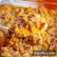 A spoonful of Southern Sweet Potato Casserole, showcasing its creamy texture and crunchy topping.