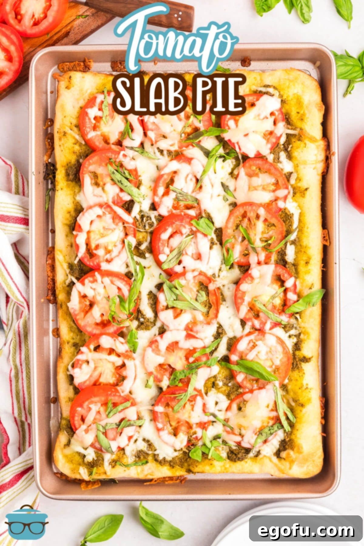 A vibrant, delicious Slab Tomato Pie baked to perfection on a full sheet pan, garnished with fresh basil and ready for slicing and serving to a crowd.