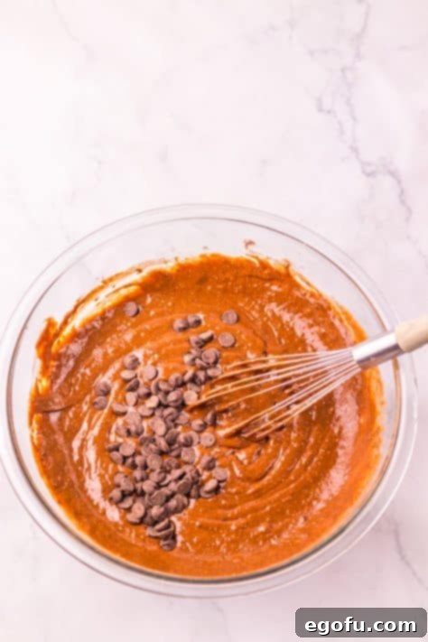 Chocolate chips being added to the muffin batter.