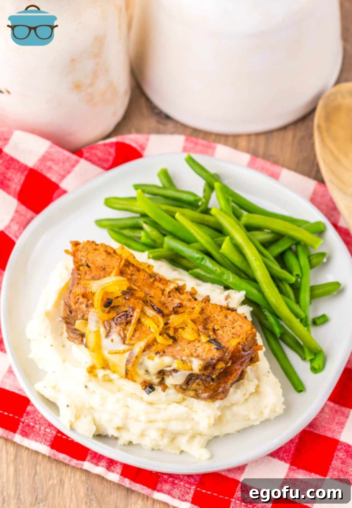 A full plate of French Onion Meatloaf with veggies and mashed potatoes, showcasing its rich, comforting appeal.