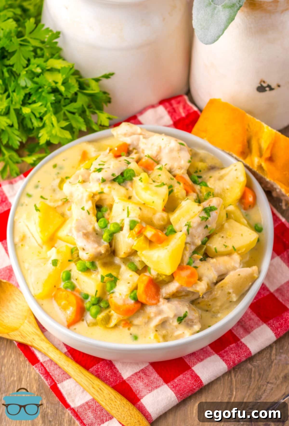 A full bowl of creamy chicken stew, garnished with fresh herbs, showcasing tender chicken and vibrant vegetables, ready to be enjoyed.