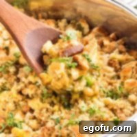 A wooden spoon getting a scoop of One Pot Chicken Stuffing Casserole.