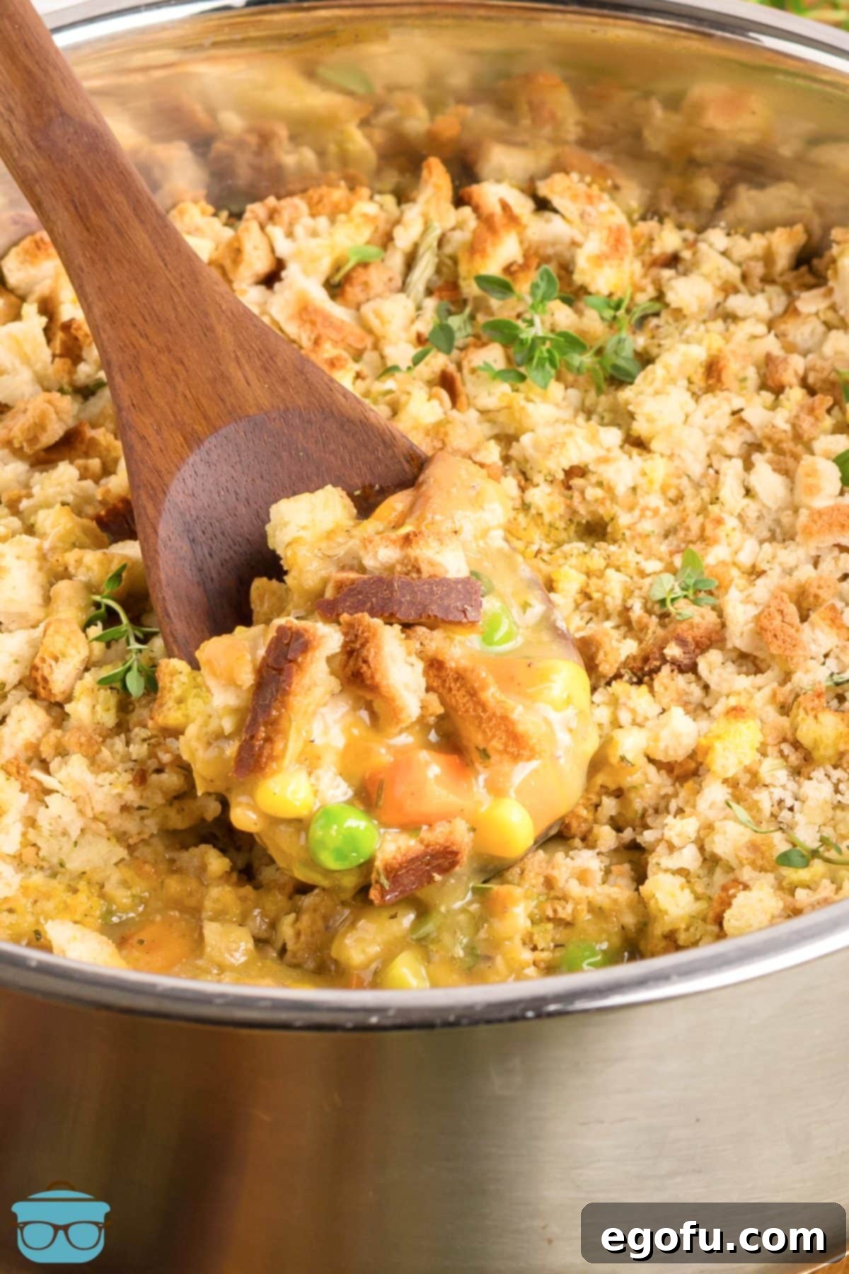 A spoon stirring a pot of Chicken Stuffing Casserole, showcasing its creamy texture.