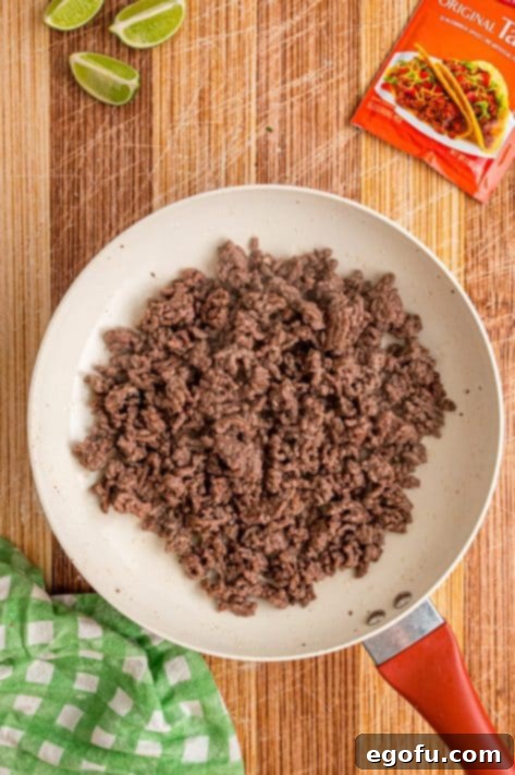 Cooked ground beef in a skillet, ready for seasoning.
