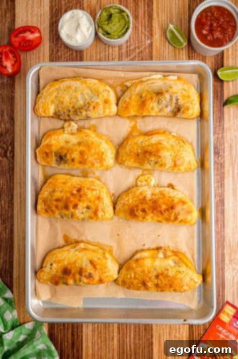 Baked Taco Pockets on a lined baking sheet, golden brown and puffed.