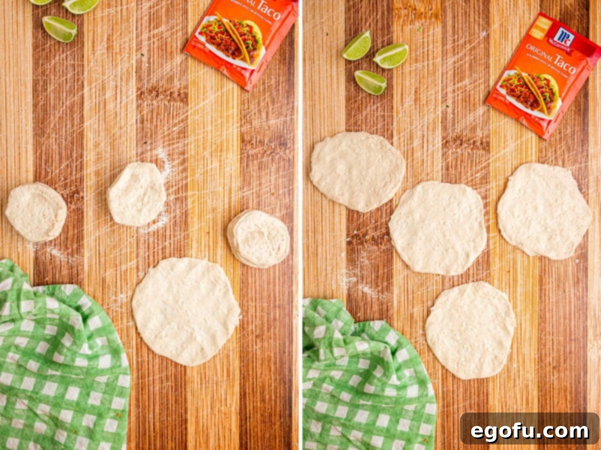 Biscuit dough being flattened out into circular shapes on a floured surface.