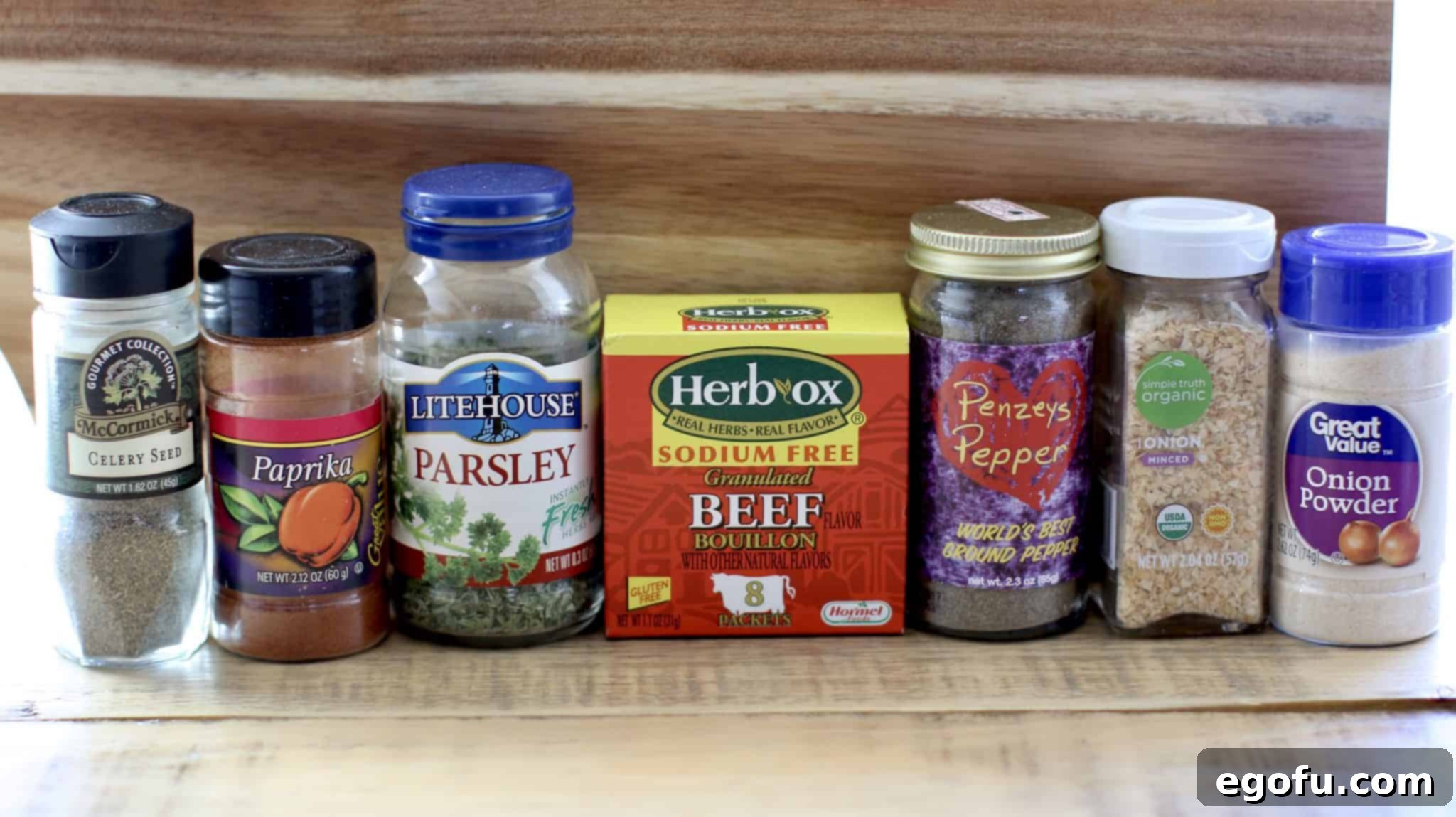 Savory Homemade Onion Soup Seasoning 6 dried onion flakes, beef bouillon granules, onion powder, parsley flakes, celery seed, paprika and black pepper shown on lined up.