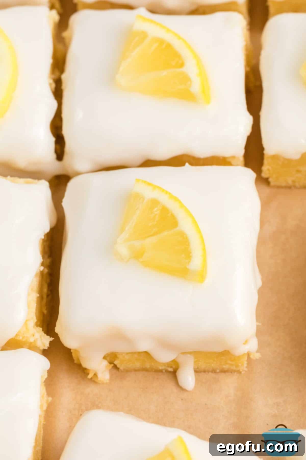 Looking down on a few freshly glazed and cut Homemade Lemon Brownies, showcasing their golden hue and inviting texture.