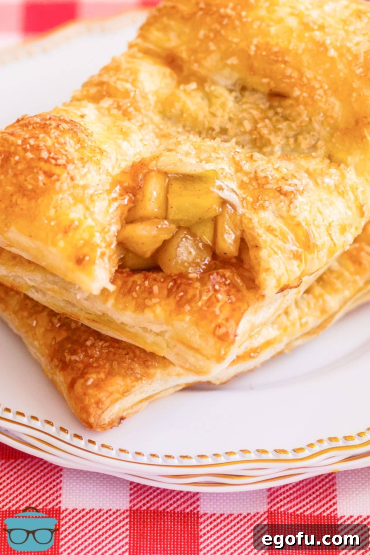 A golden, flaky Puff Pastry Apple Pie with the end torn open, revealing the warm, cinnamon-spiced apple filling.