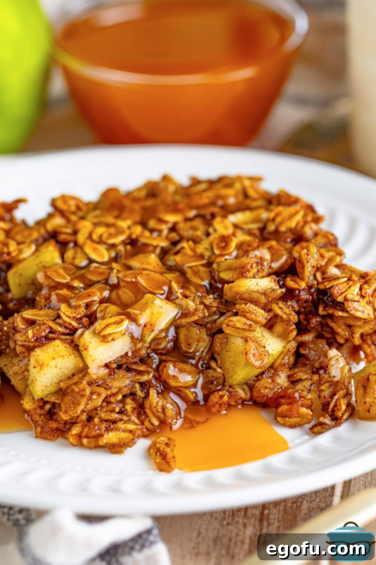 A generous serving of Apple Baked Oatmeal drizzled with caramel and maple syrup, ready to be enjoyed.