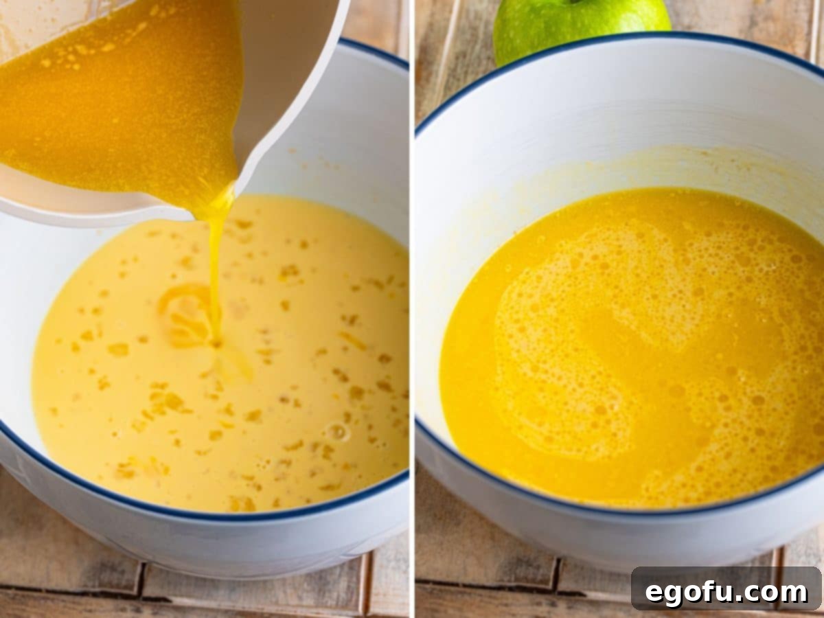 Liquid melted butter being carefully added to the already combined wet ingredient mixture, preparing it for the dry ingredients.
