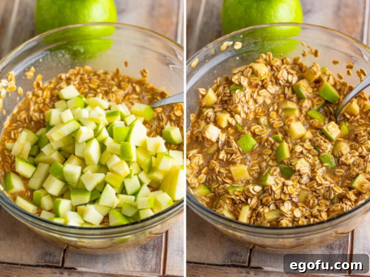 Freshly diced apples being carefully folded into the prepared oatmeal mixture, ready for baking.