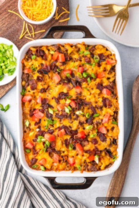 Cheesy Bacon Burger Bake 11 A freshly baked Bacon Cheeseburger Casserole, golden and bubbling, elegantly garnished with fresh diced tomatoes and chopped green onions.