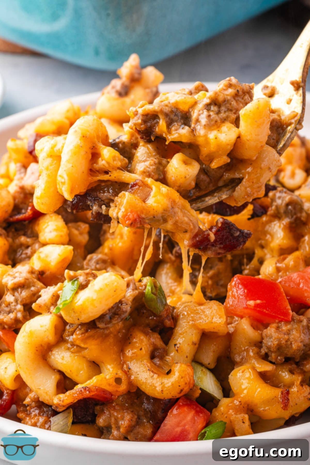 Cheesy Bacon Burger Bake 12 A serving spoon scooping a delicious portion of Bacon Cheeseburger Casserole from the baking dish, showing off its creamy texture and rich ingredients.