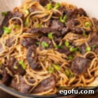 Closely looking at a plate of Mongolian Beef Noodles.