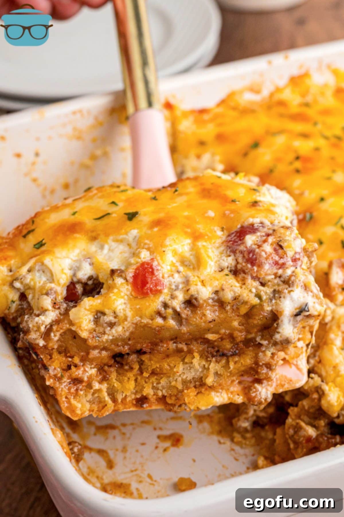 A serving utensil getting a large scoop of Cattle Drive Casserole, showcasing its delicious layers.