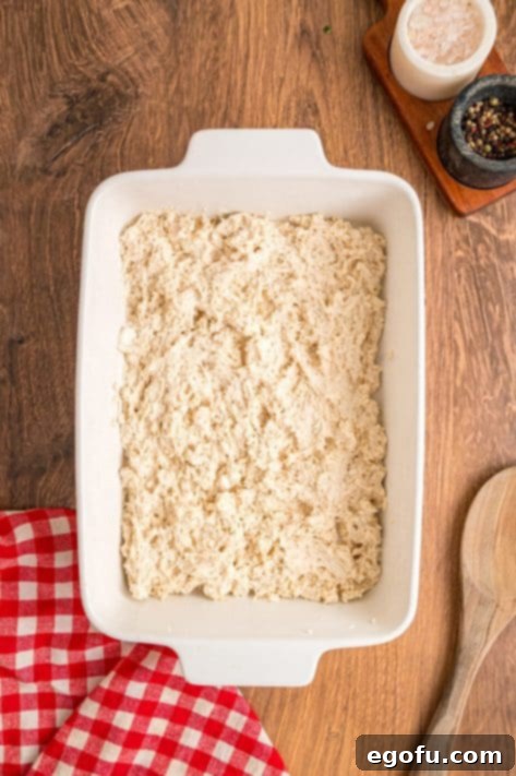 Biscuit dough spread over a baking dish.