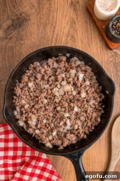 Cooked ground beef and onion in a skillet.