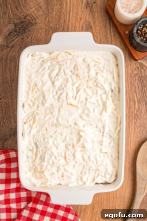 Sour cream mixture spread over the beef and biscuit layers.