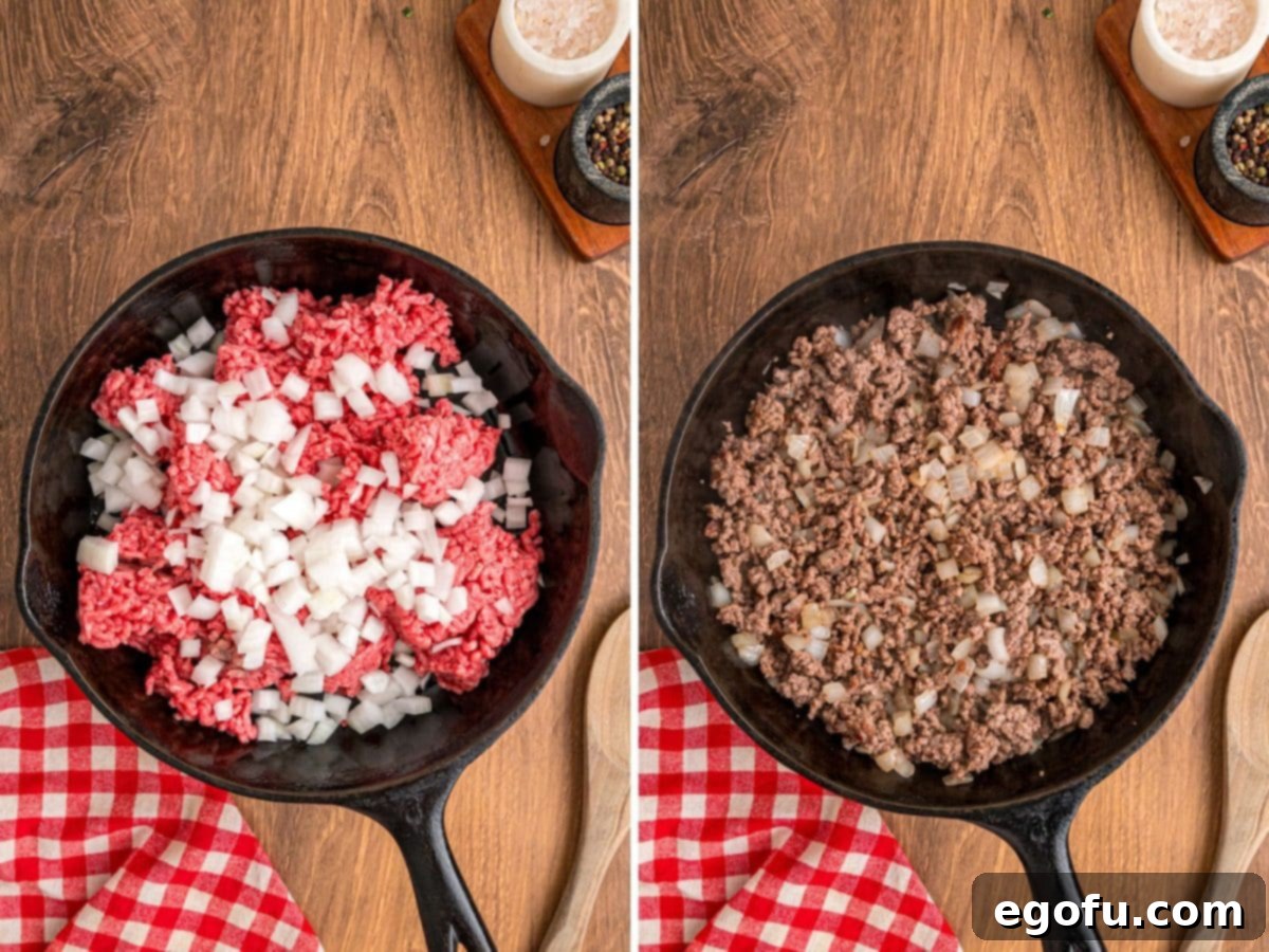 Ground beef and diced onion being cooked in a large skillet over medium heat, browning evenly.