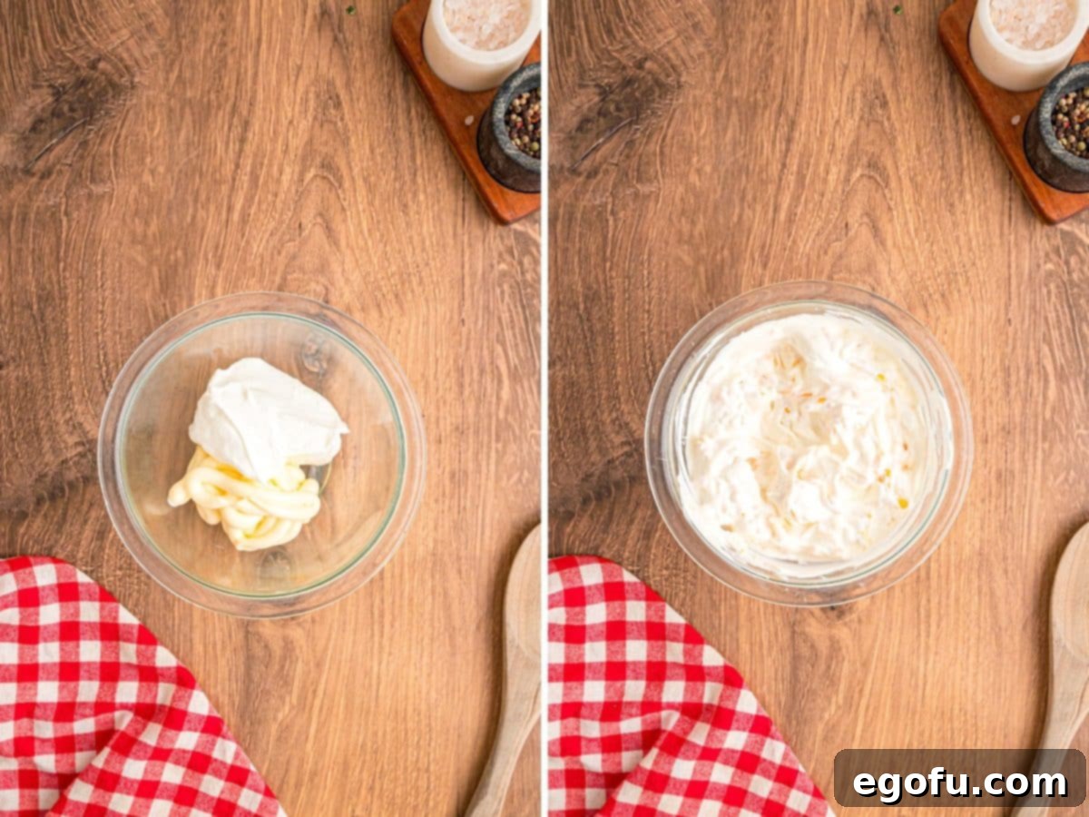 A small bowl containing the creamy topping mixture of mayonnaise, sour cream, and shredded Colby Jack cheese, ready to be spread.