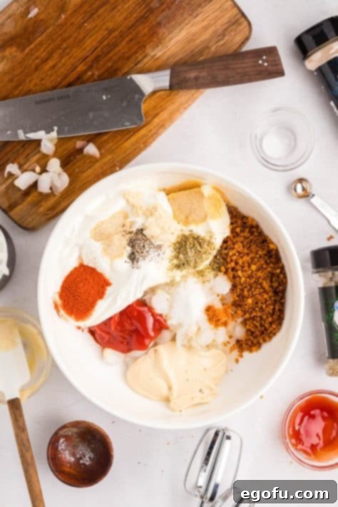 All creamy dip ingredients being mixed in a large bowl.