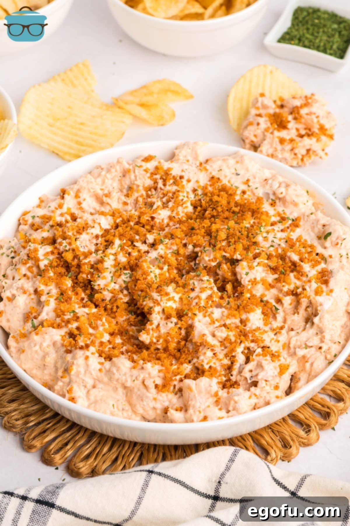 A large appetizer bowl filled with creamy Bloomin' Onion Dip, garnished with toasted breadcrumbs and fresh parsley.