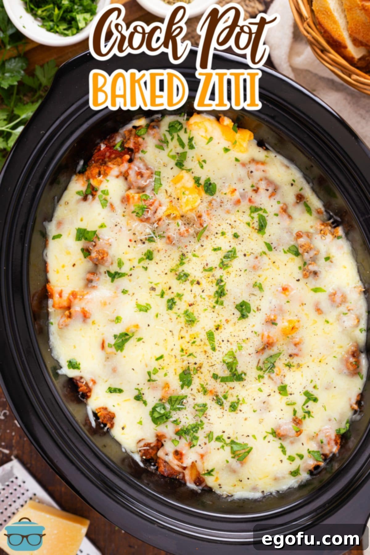 An overhead view of a full slow cooker insert brimming with piping hot Crock Pot Baked Ziti, topped with melted cheese and ready to serve.