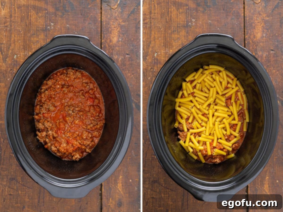 Uncooked ziti pasta carefully layered over a rich meat sauce in the base of a slow cooker, illustrating the first layer of the Crock Pot Baked Ziti.