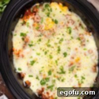 An appetizing close-up of the Crock Pot insert, full to the brim with bubbly, cheesy Baked Ziti, showcasing its rich texture and inviting warmth.