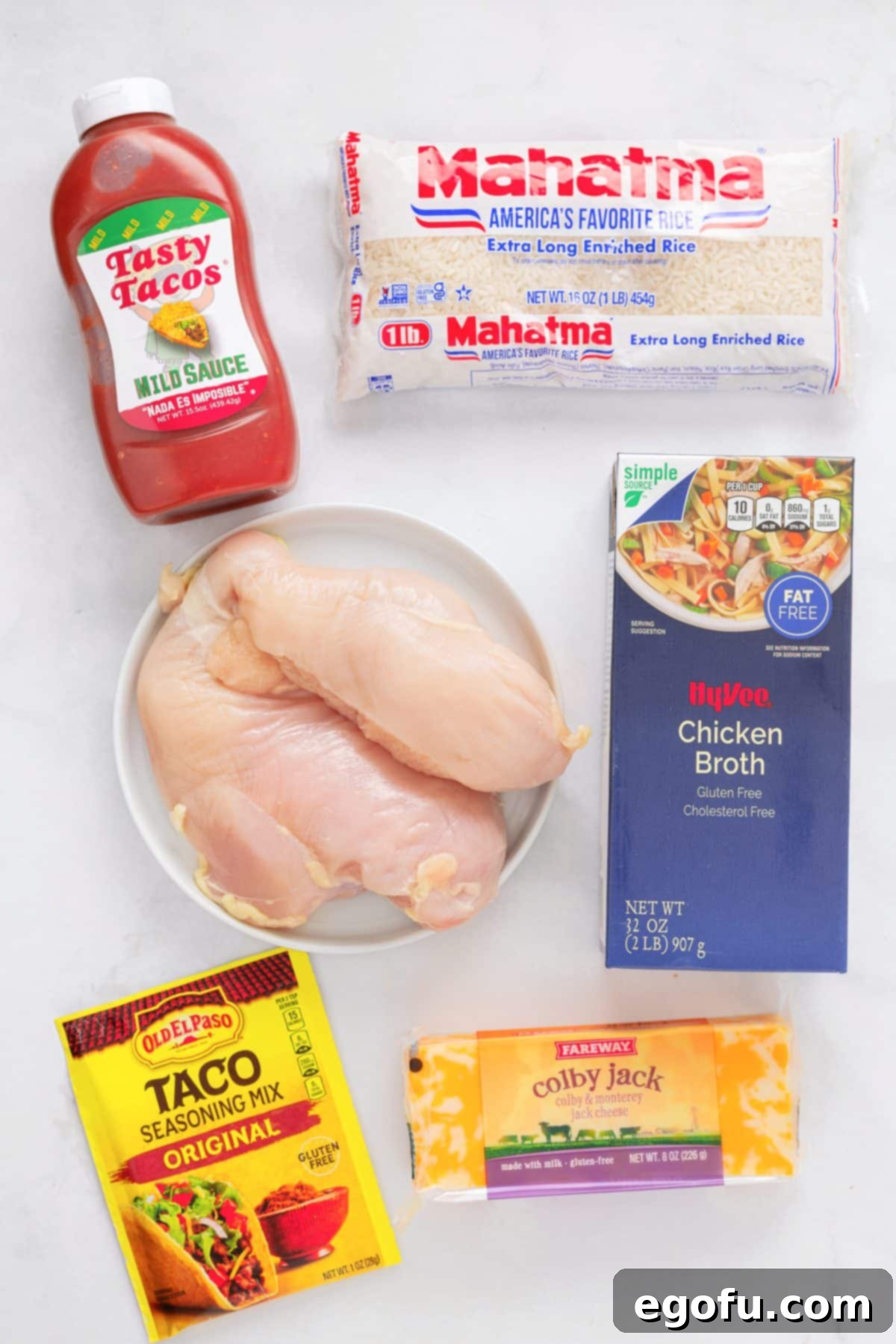 Taco sauce, rice, chicken breast, chicken broth, taco seasoning, and a block of cheese. 