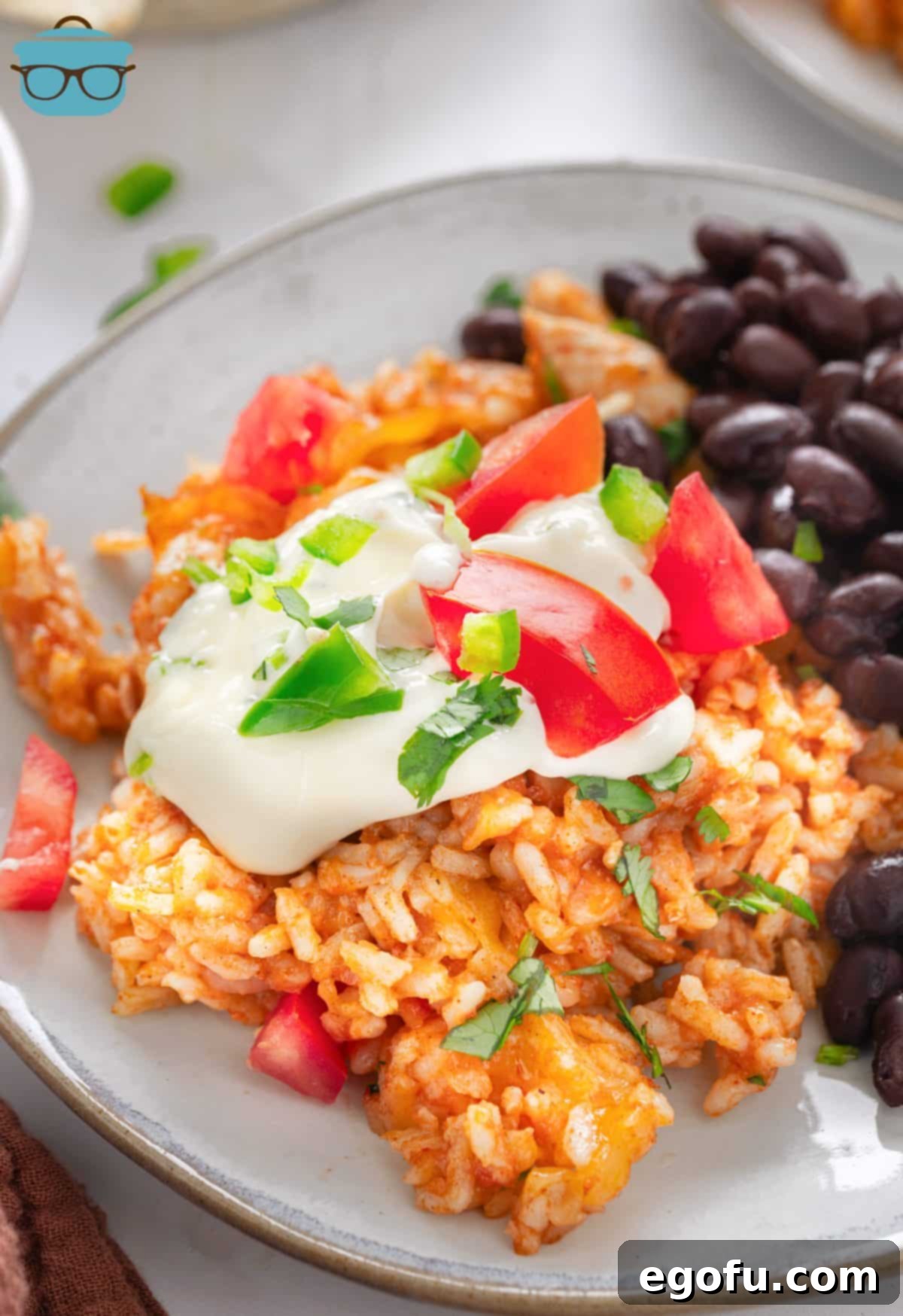 A plate of Chicken Taco Rice with beans.