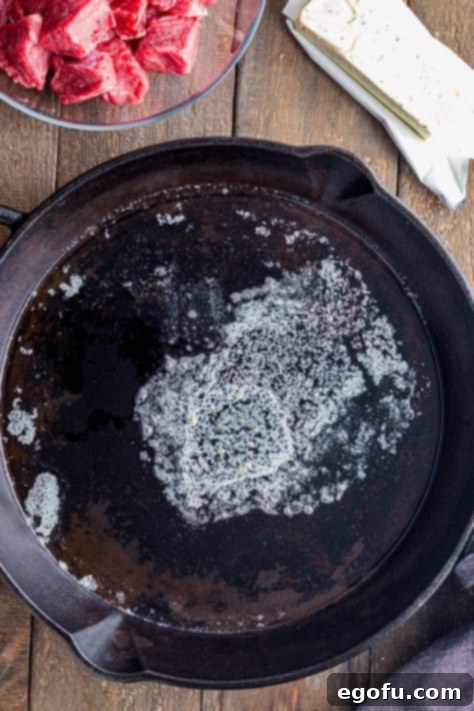 Pan-Seared Garlic Butter Steak Bites with Crispy Potatoes 11 Olive oil and butter melting in a hot cast iron skillet.