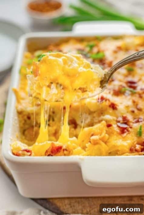 A scoop of Chicken Hash Brown Casserole above the casserole dish.