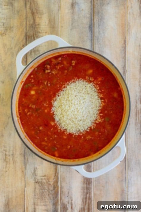 Rice being added to the casserole mix.