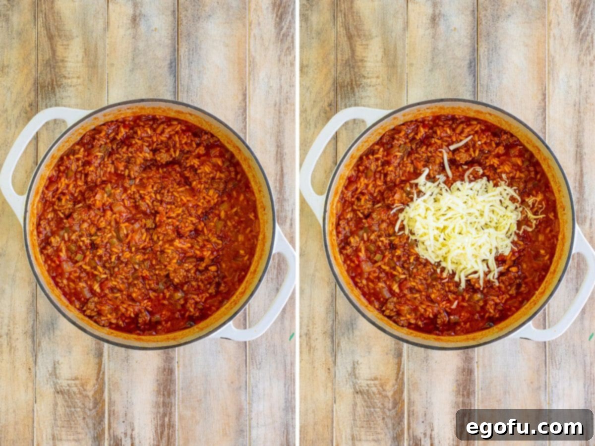 A bubbling, saucy casserole, almost ready, with half of the mozzarella cheese already stirred in, creating creamy pockets of melted goodness.