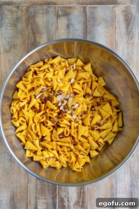 Bugles, pecans and almonds tossed together in a bowl.