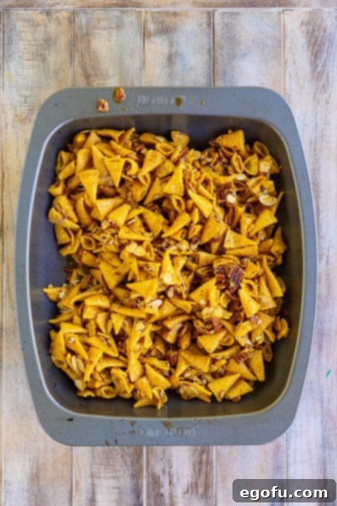 Freshly baked Bugle Sweet Party Mix, glistening with caramel, cooling in a dish.