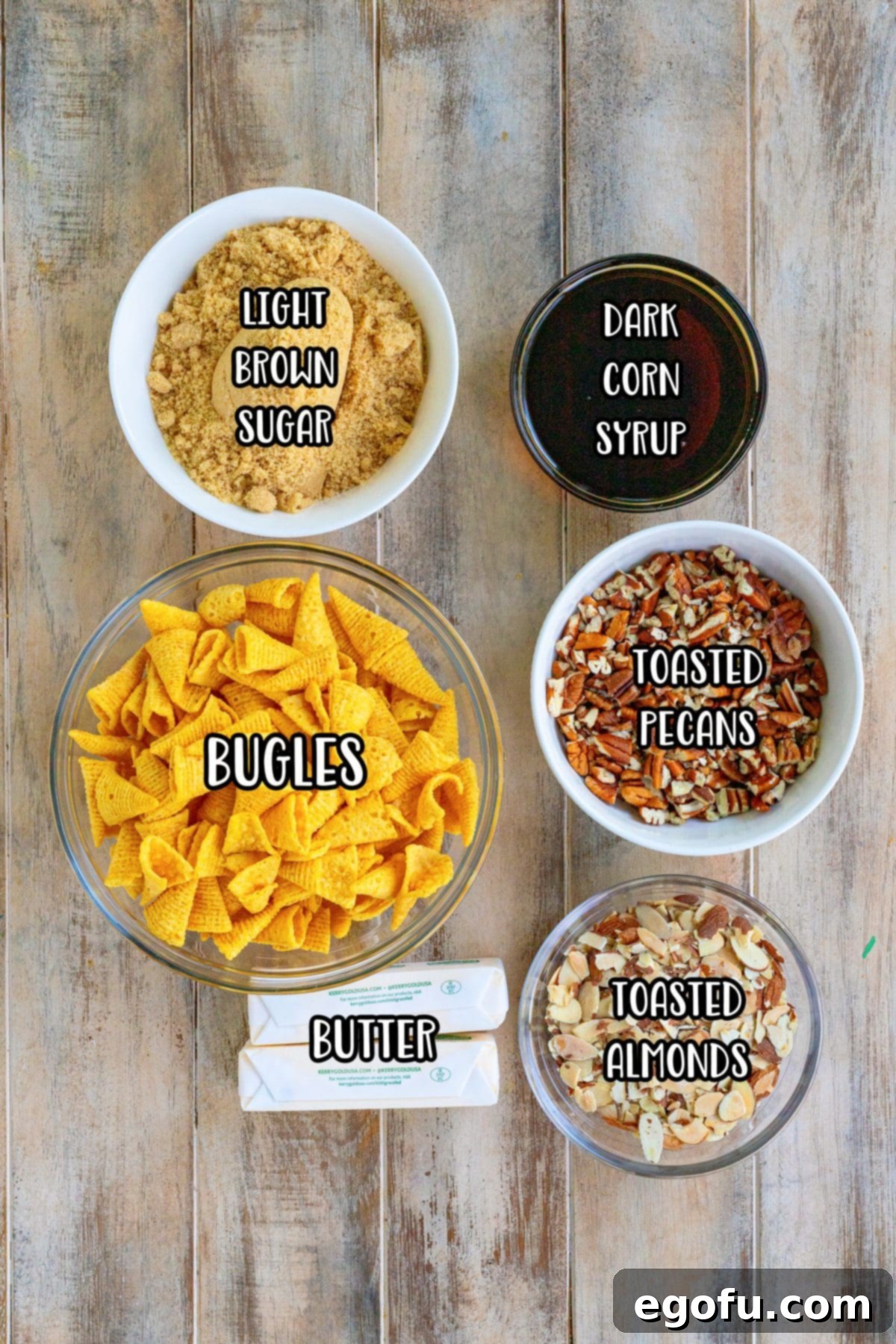 A flat lay of the essential ingredients: Bugles, light brown sugar, unsalted butter, toasted sliced almonds, toasted chopped pecans, and dark corn syrup.