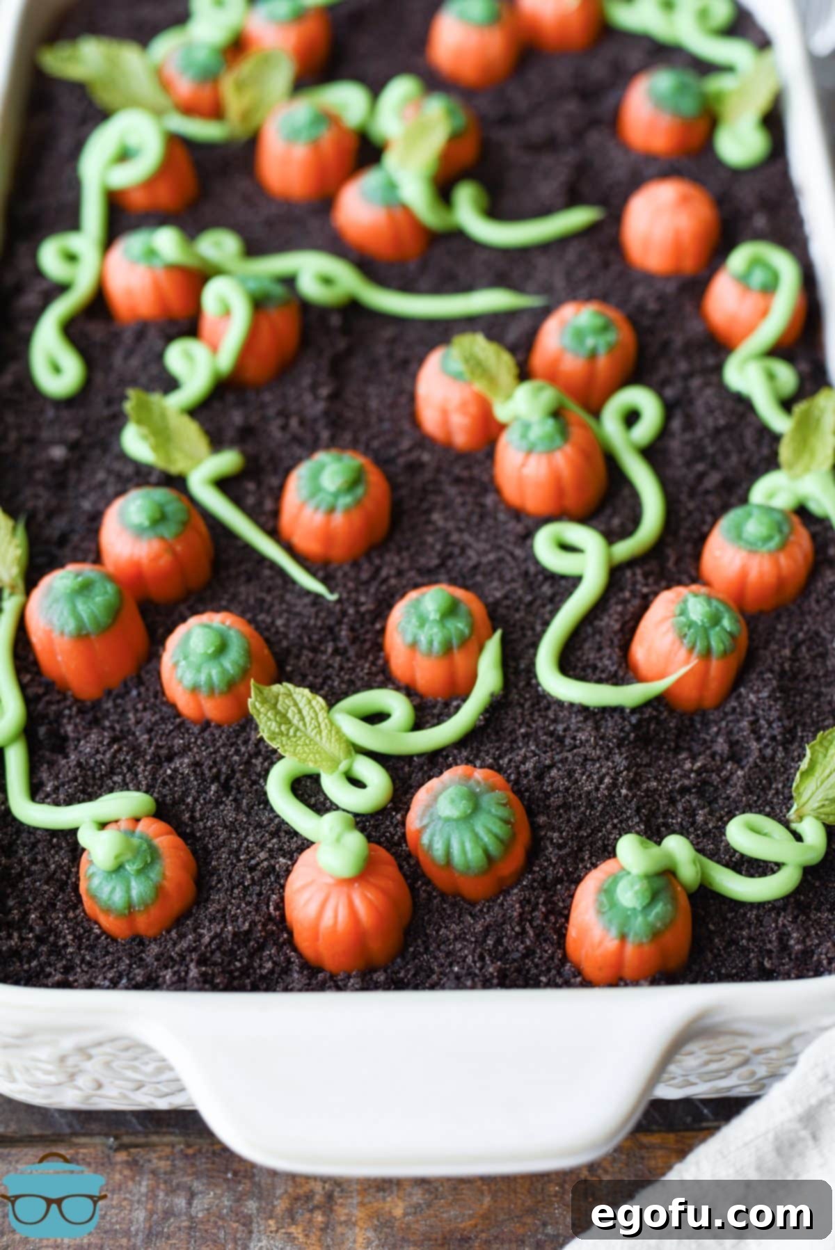 A chocolate pudding pumpkin patch dessert with frosting vines and marshmallow creme pumpkins.