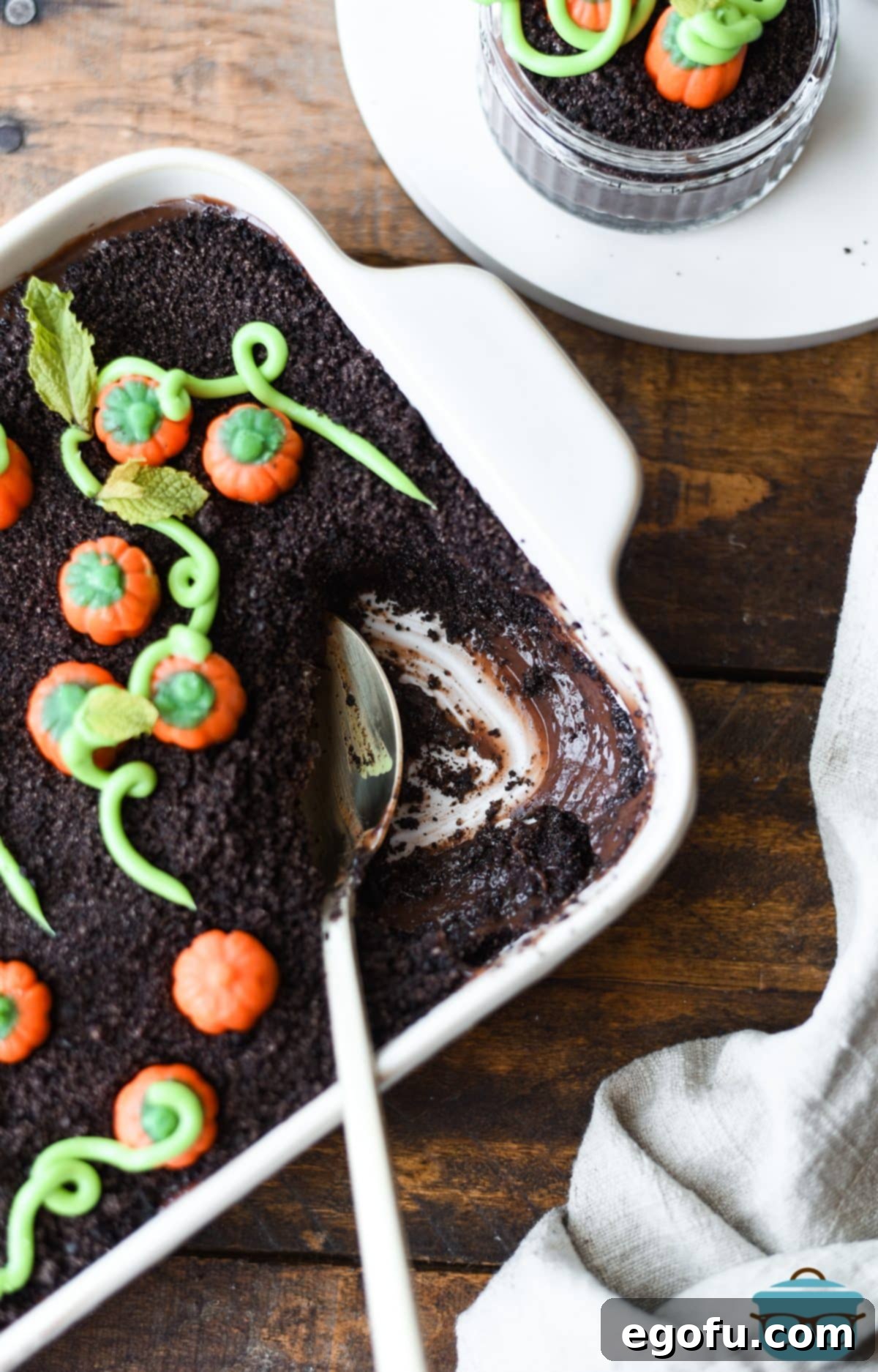 A spoon getting a scoop of Pumpkin Patch Dirt Pudding, showcasing the layers.